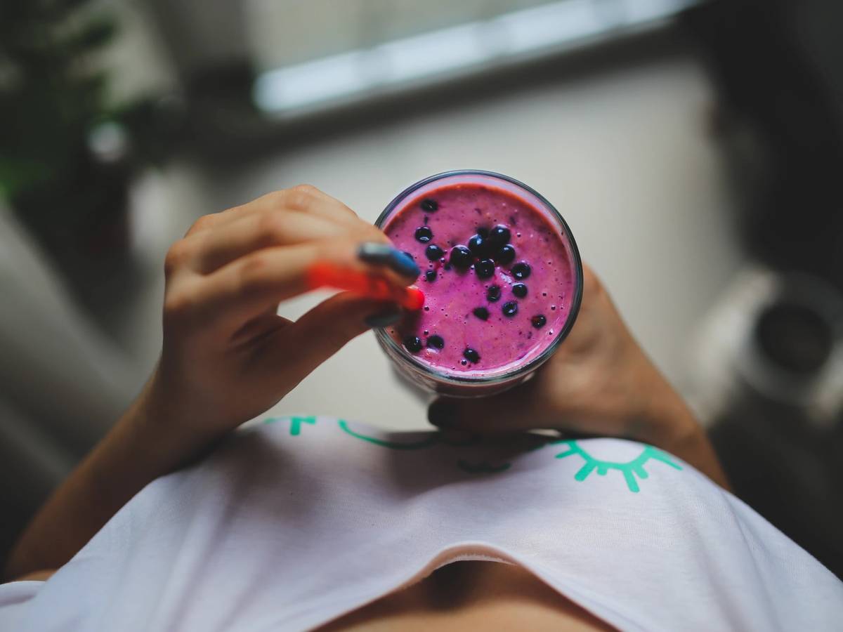 woman holding smoothie rich in fiber to stay fuller longer