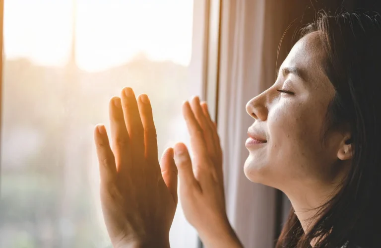 Woman enjoying the sun by a window
